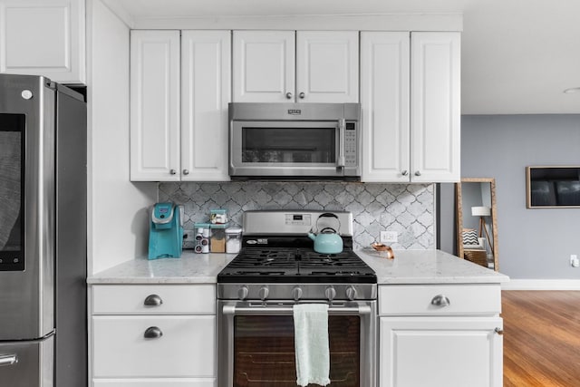 7611 Providence Ave Unit A, Austin, TX 78752 - kitchen featuring appliances with stainless steel finishes, tasteful backsplash, white cabinetry, and light stone counters