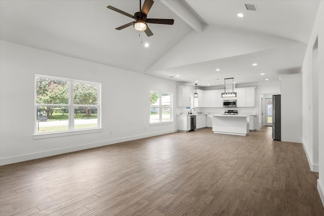 unfurnished living room with a wealth of natural light, ceiling fan, high vaulted ceiling, and hardwood / wood-style flooring