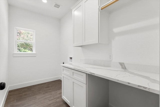 clothes washing area featuring dark hardwood / wood-style floors, cabinets, and hookup for a washing machine