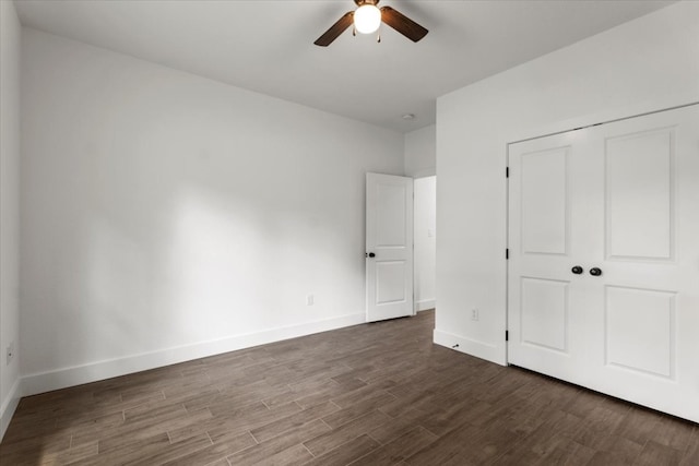 unfurnished bedroom with a closet, dark hardwood / wood-style floors, and ceiling fan