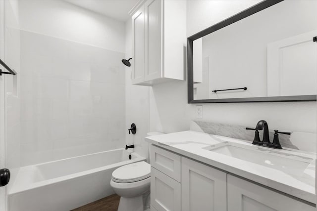 full bathroom featuring vanity, tiled shower / bath combo, hardwood / wood-style flooring, and toilet