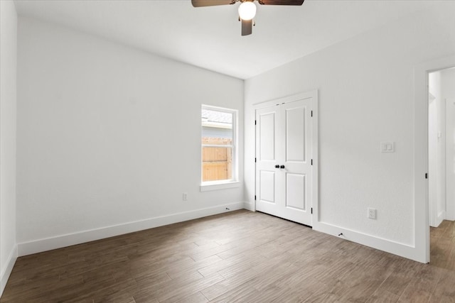 unfurnished bedroom featuring ceiling fan, a closet, and hardwood / wood-style flooring