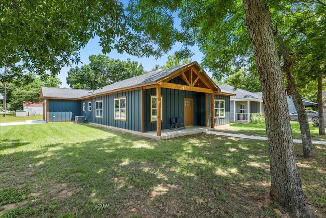 view of front of house with a front lawn and cooling unit