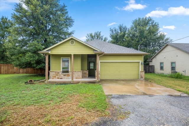 view of front of home featuring a garage, covered porch, and a front yard