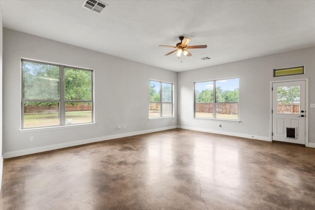 spare room with a textured ceiling, ceiling fan, and a healthy amount of sunlight