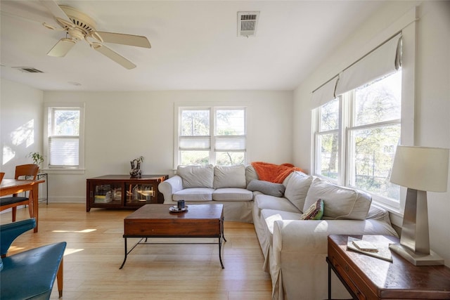 living room featuring ceiling fan, a healthy amount of sunlight, and light wood-type flooring