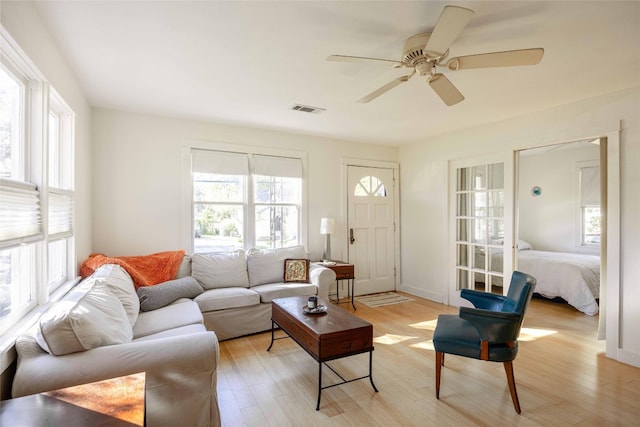 living room with ceiling fan and light wood-type flooring