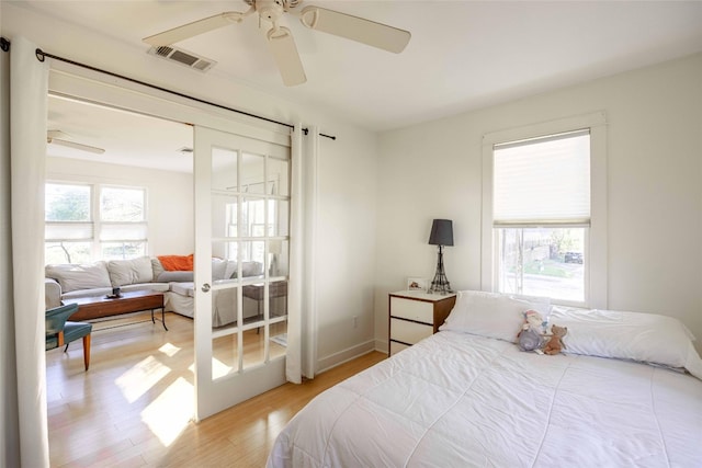 bedroom with french doors, hardwood / wood-style flooring, and ceiling fan