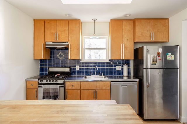 kitchen with tasteful backsplash, sink, decorative light fixtures, and appliances with stainless steel finishes