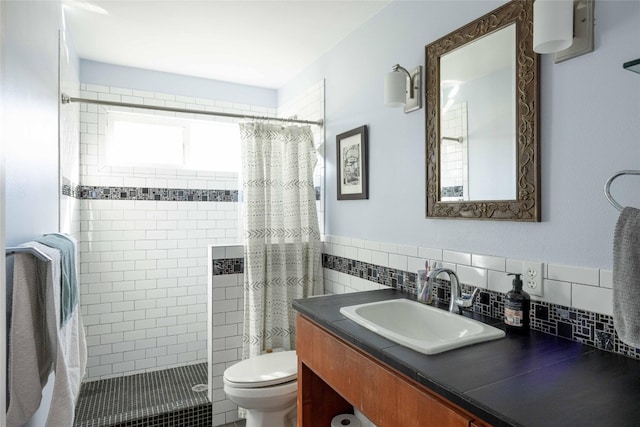 bathroom with a shower with curtain, vanity, toilet, and tile walls