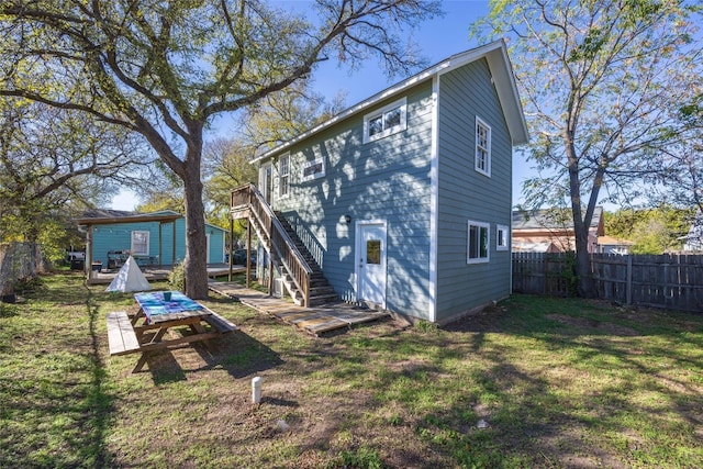 rear view of house with a deck and a yard