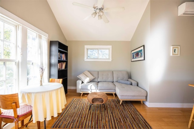 living room with ceiling fan, a healthy amount of sunlight, lofted ceiling, and light hardwood / wood-style floors