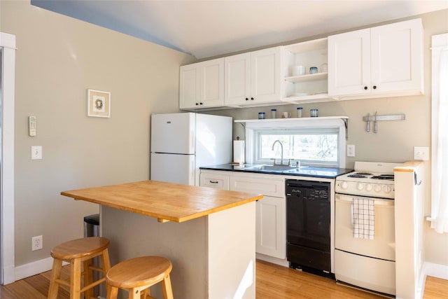 kitchen featuring a kitchen breakfast bar, white appliances, sink, white cabinetry, and butcher block counters