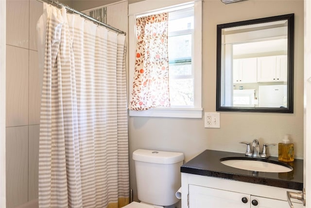 bathroom featuring a shower with shower curtain, vanity, and toilet