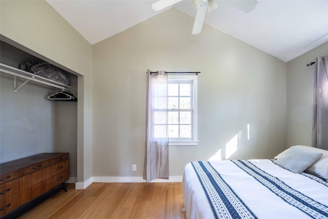 bedroom with ceiling fan, a closet, hardwood / wood-style floors, and lofted ceiling