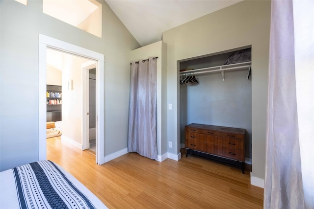 unfurnished bedroom featuring a closet, lofted ceiling, and hardwood / wood-style flooring