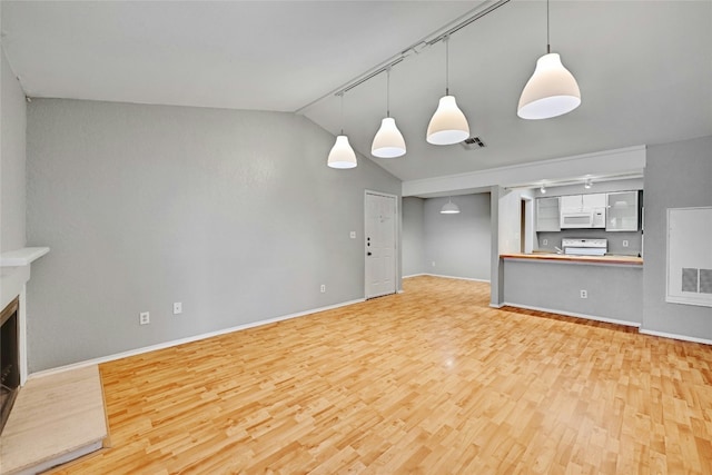 unfurnished living room featuring light wood-type flooring, vaulted ceiling, and track lighting