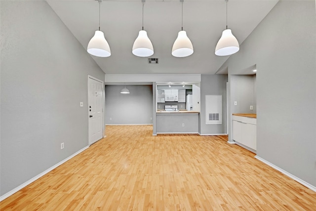 unfurnished living room featuring lofted ceiling and light hardwood / wood-style flooring