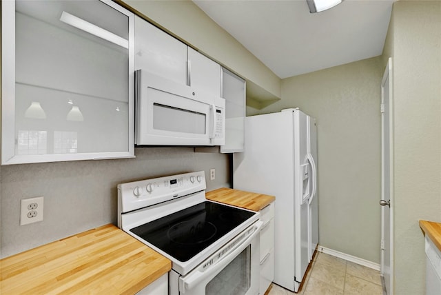 kitchen with light tile patterned floors, butcher block counters, white appliances, and white cabinetry