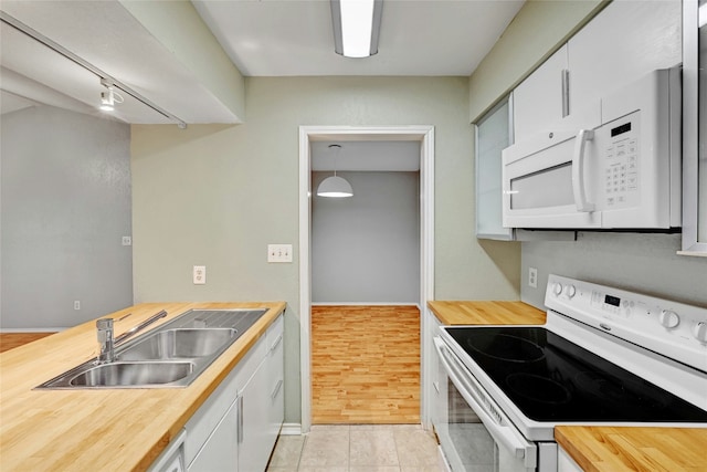 kitchen with white cabinets, butcher block countertops, sink, and white appliances