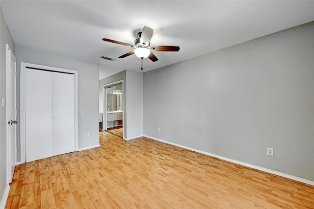 unfurnished bedroom featuring ceiling fan, a closet, ensuite bathroom, and light hardwood / wood-style floors