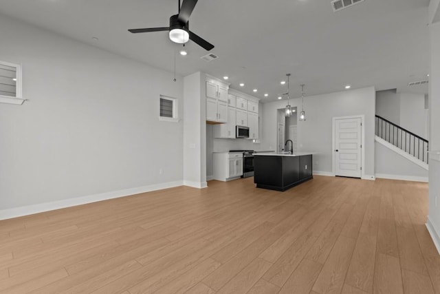 708 Terrier Trl, Austin, TX 78745 - unfurnished living room featuring ceiling fan, light wood-style floors, stairway, and recessed lighting