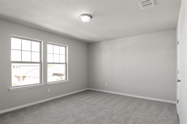 unfurnished room with light carpet and a textured ceiling