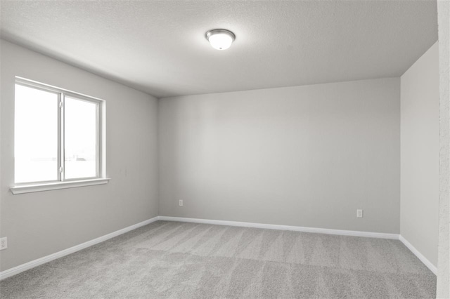 unfurnished room with light carpet and a textured ceiling