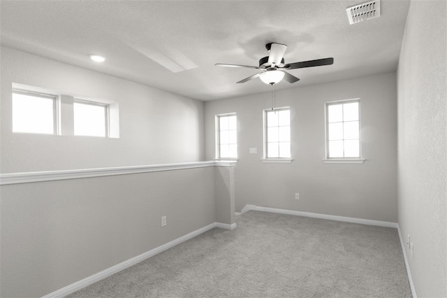 carpeted empty room featuring a textured ceiling and ceiling fan