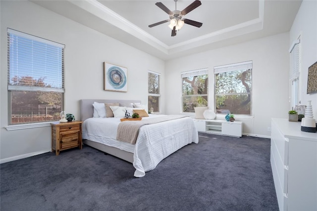 bedroom with a tray ceiling, dark colored carpet, and ceiling fan