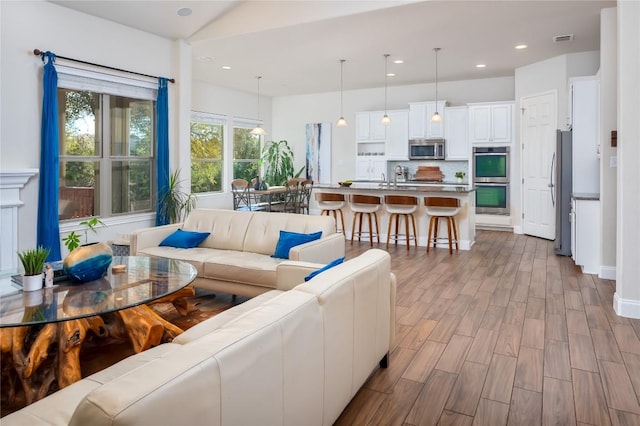 living room featuring sink and light hardwood / wood-style floors