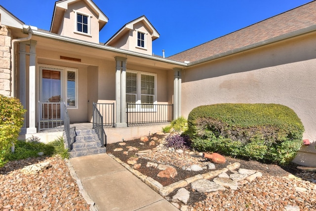 view of exterior entry featuring covered porch