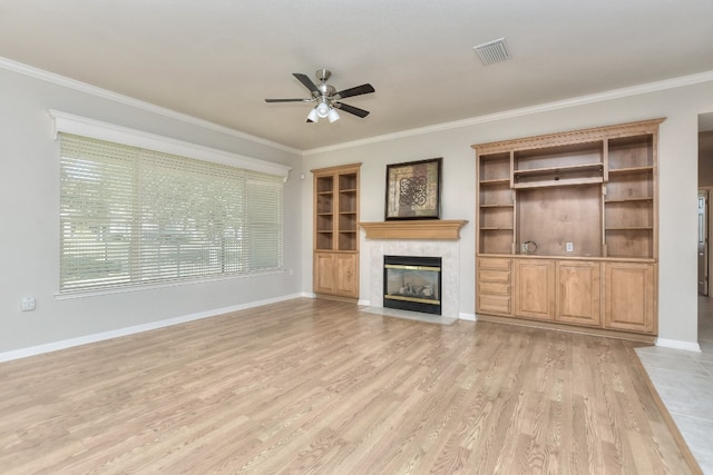 unfurnished living room featuring light hardwood / wood-style floors, crown molding, and a premium fireplace