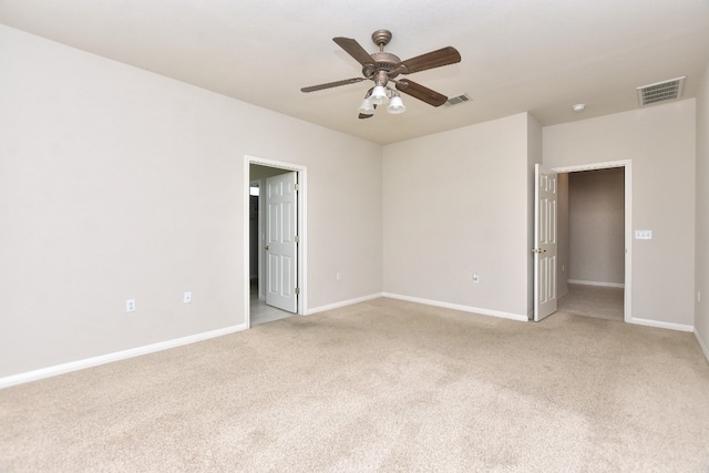 empty room featuring ceiling fan and light colored carpet