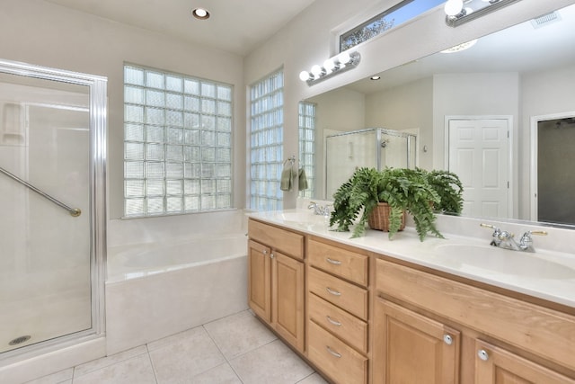 bathroom with tile patterned floors, vanity, and plus walk in shower