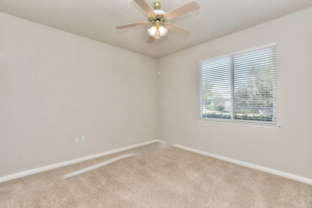 empty room featuring ceiling fan and carpet