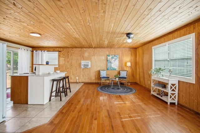 dining space featuring wood ceiling, a healthy amount of sunlight, and wood walls