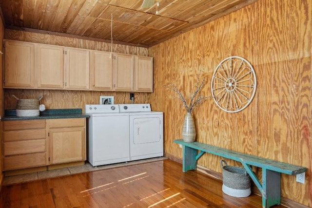 washroom with wood walls, cabinets, wood-type flooring, separate washer and dryer, and wooden ceiling