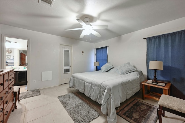 tiled bedroom with ceiling fan, a textured ceiling, and ensuite bath