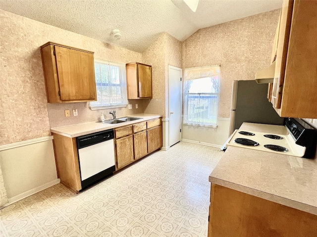 kitchen with a textured ceiling, lofted ceiling, sink, and white appliances