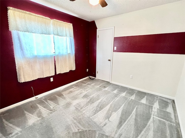 unfurnished room featuring carpet, ceiling fan, and a textured ceiling