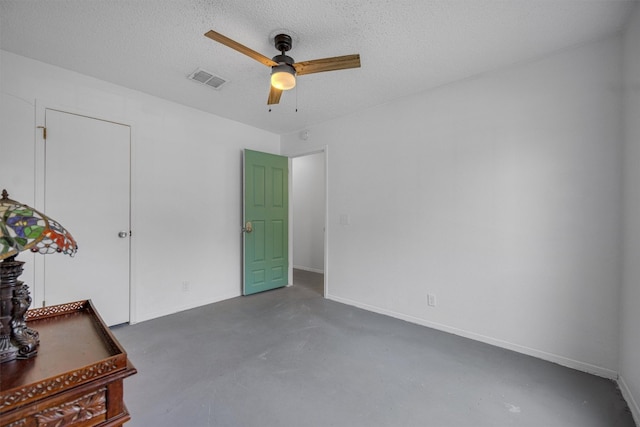 empty room featuring ceiling fan and a textured ceiling