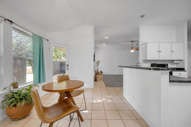 tiled dining area with ceiling fan and sink