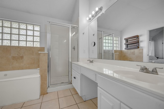 bathroom featuring tile patterned flooring, vanity, vaulted ceiling, and plenty of natural light