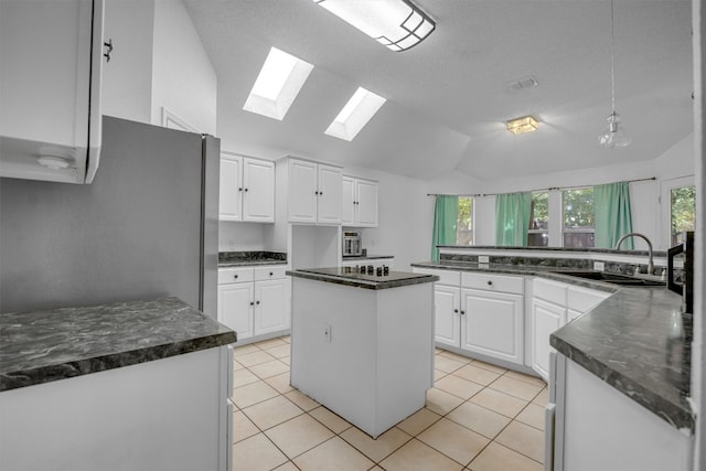 kitchen featuring white cabinetry, a wealth of natural light, sink, and a kitchen island