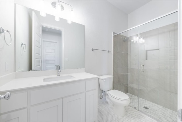 bathroom with tile patterned floors, vanity, toilet, and a shower with door