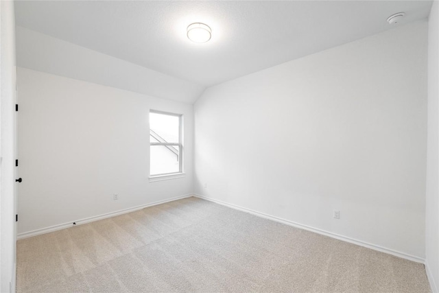 empty room with light carpet and lofted ceiling