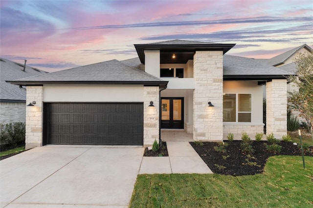 prairie-style house featuring french doors and a garage