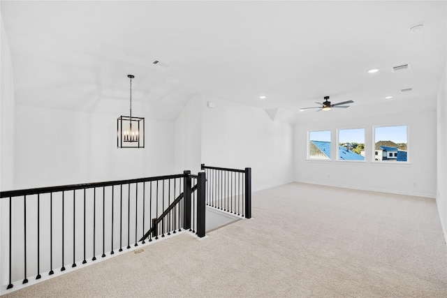 hallway with a notable chandelier, light colored carpet, and lofted ceiling