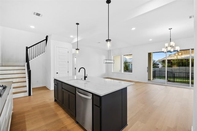 kitchen with light stone counters, stainless steel dishwasher, sink, a center island with sink, and a notable chandelier